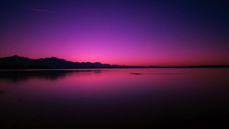 a purple and pink sky over a lake